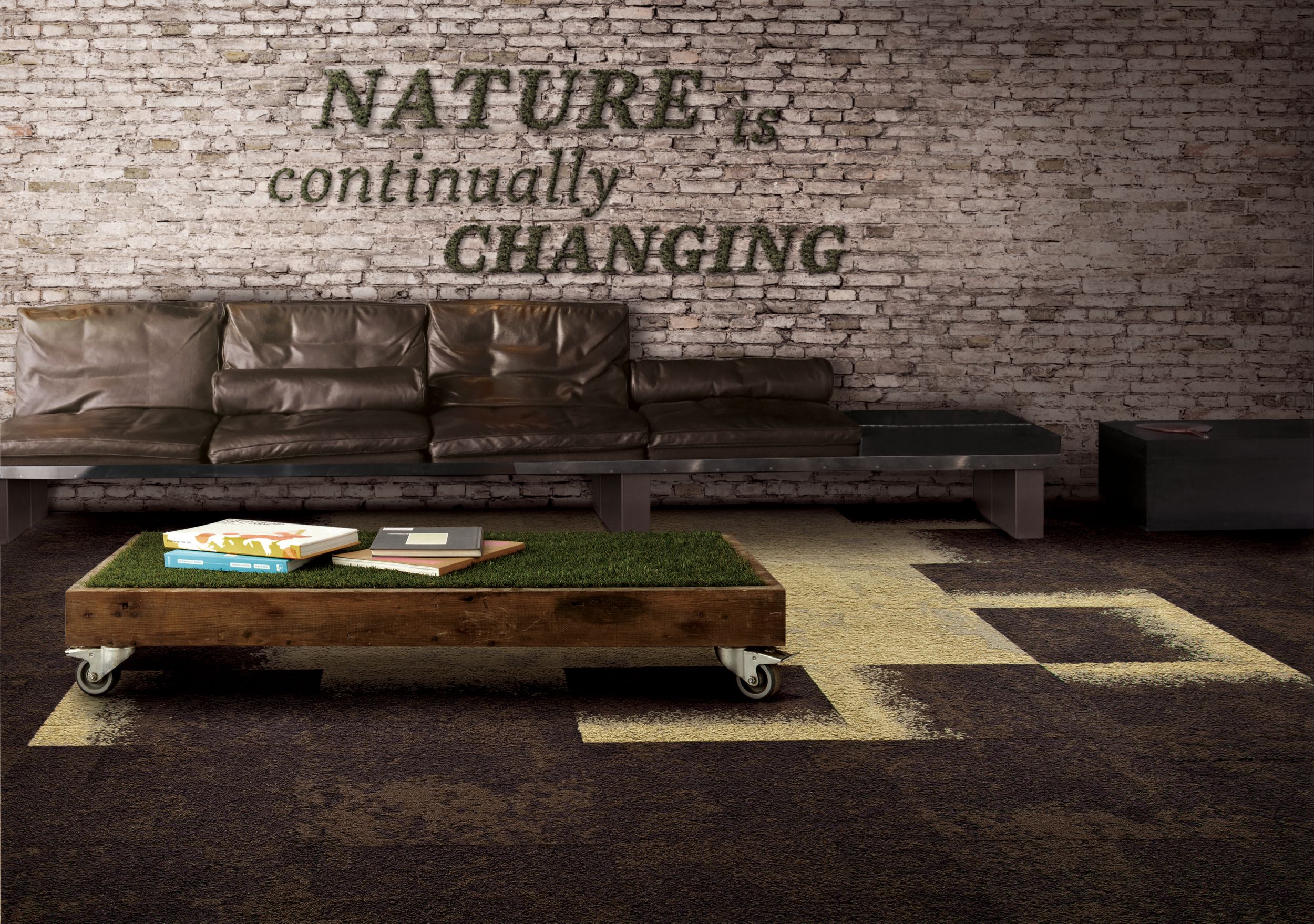 Interface, UR101, UR102 and UR103 carpet tile in seating area with brown sofa, wood coffee table with "grass" top and exposed brick wall image number 7